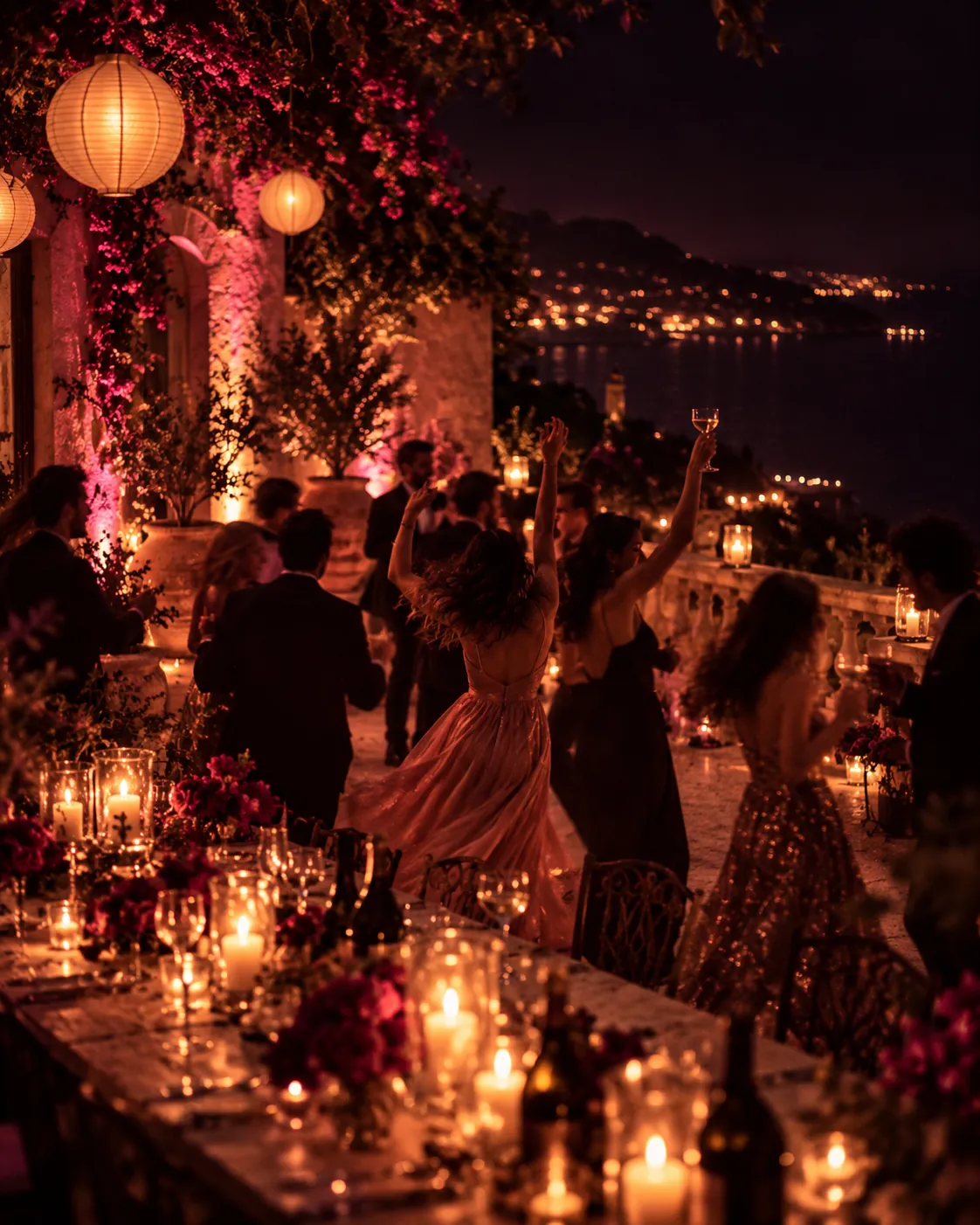 Soirée entre amis sur une terrasse au-dessus de la mer, la nuit : danse, verres levés, bougies et lanternes
